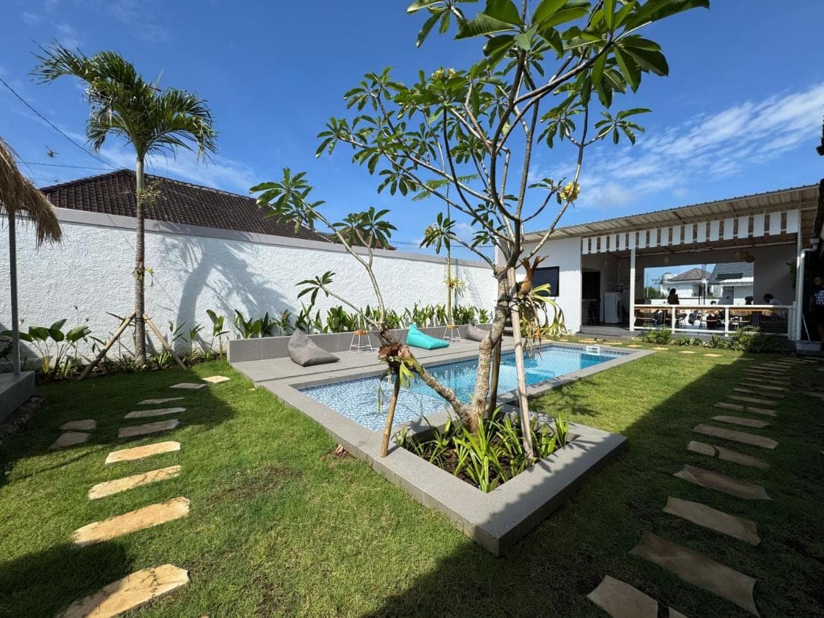 a backyard with a swimming pool and a tree at WISH Stay-Surf-Relax in Uluwatu