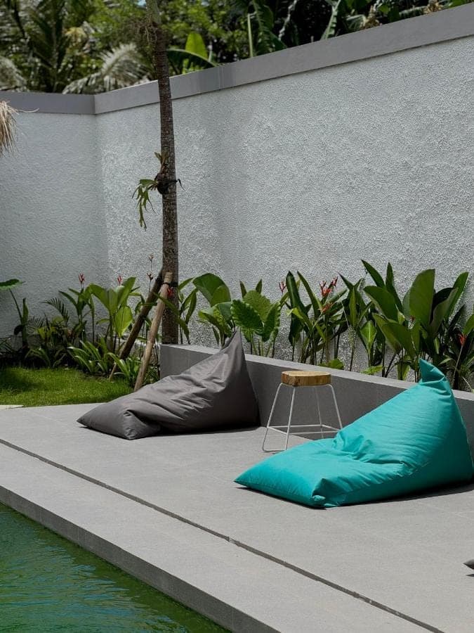 a bed with pillows on it next to the water at WISH Stay-Surf-Relax in Uluwatu