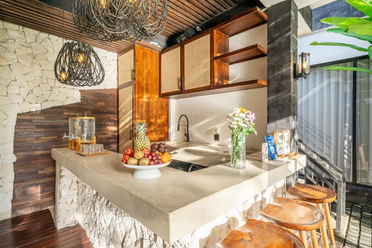 a kitchen with a counter with a bowl of fruit on it at Sebelas Apartments by EVDEkimi - Modern Stay with Pool near Dining & Shops in Ubud