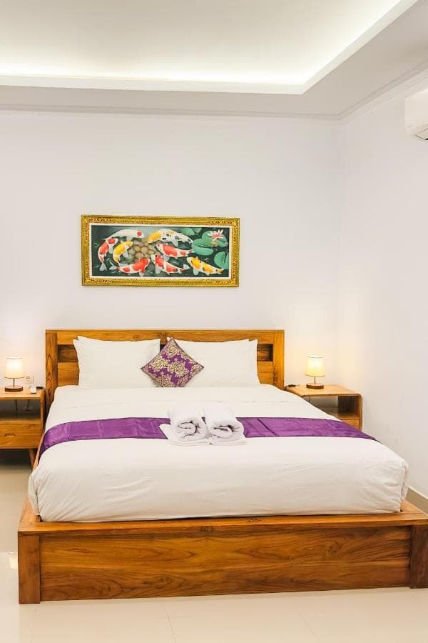 a bedroom with a large bed with two night stands at Anantalla Homestay in Sidemen