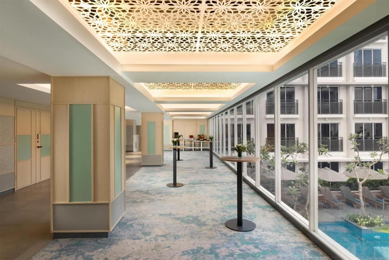 an office lobby with a hallway with windows at Hilton Garden Inn Bali Nusa Dua in Nusa Dua