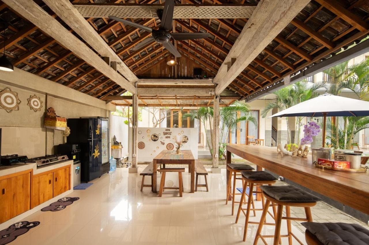 a kitchen with a long counter and a table at Canggu Nadi 2 Guest House in Canggu