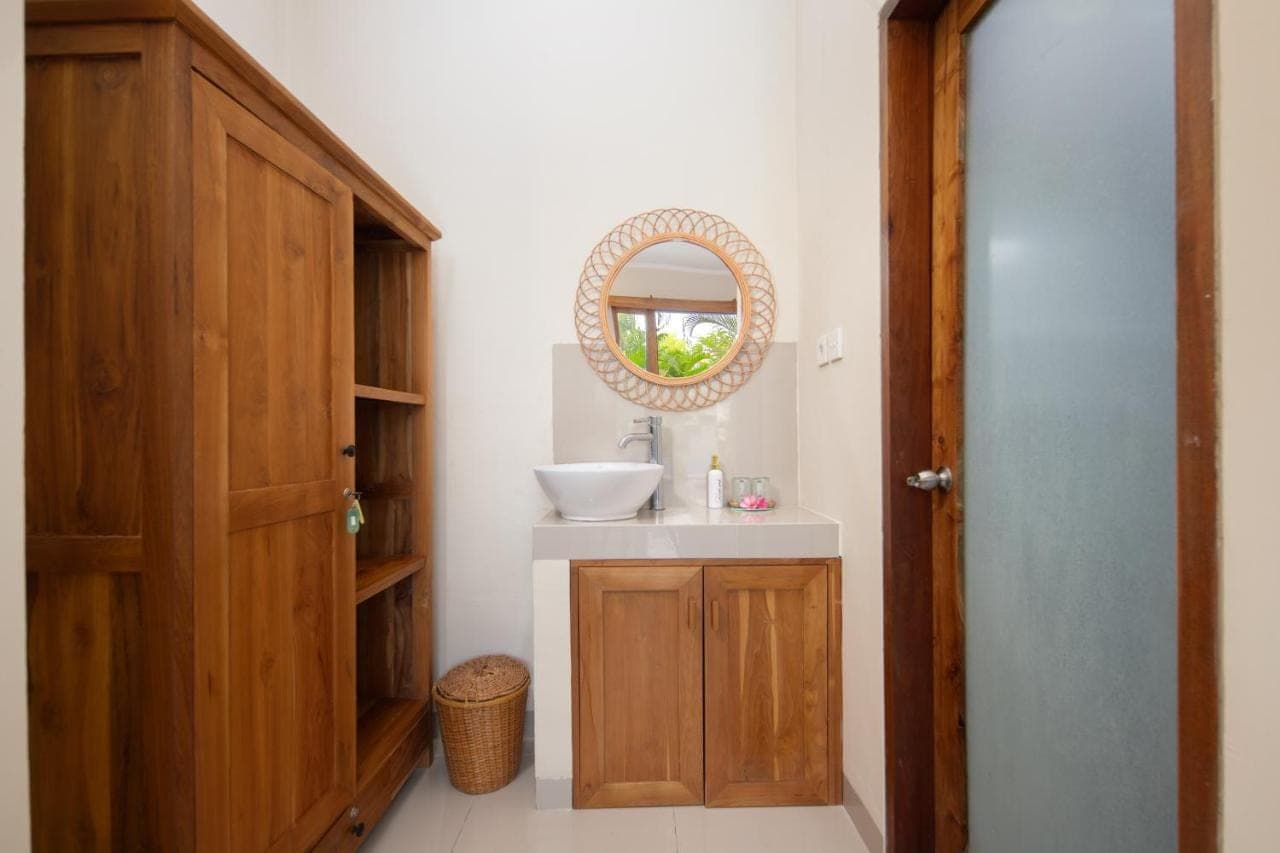 a bathroom with a sink and a mirror at Canggu Nadi 2 Guest House in Canggu