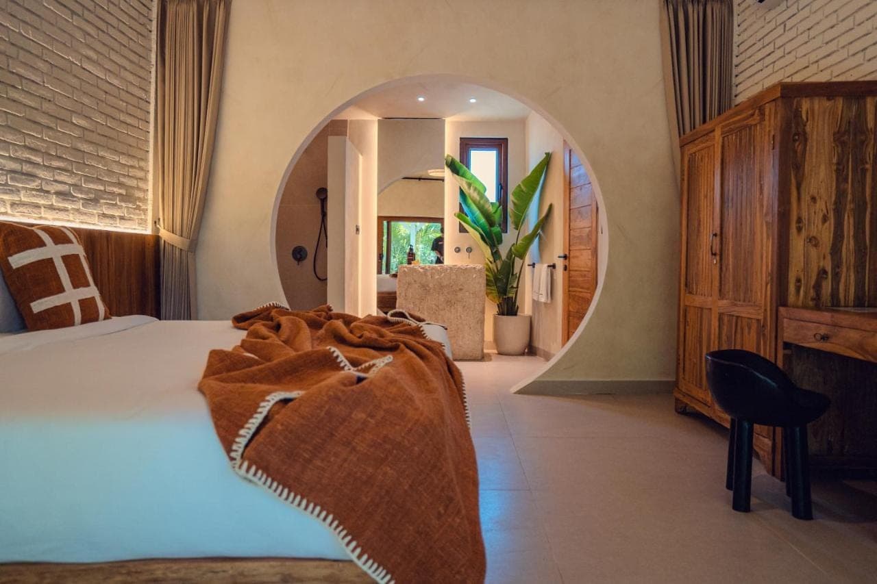 a bedroom with a bed and a large mirror at Lunatica Bali in Uluwatu