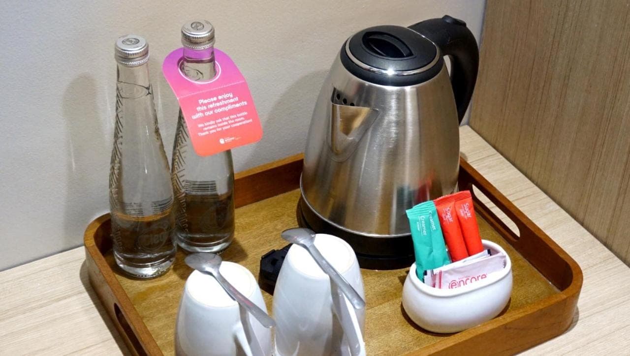 a wooden tray with a coffee maker and a tea kettle at Ramada Encore by Wyndham Seminyak Bali in Seminyak