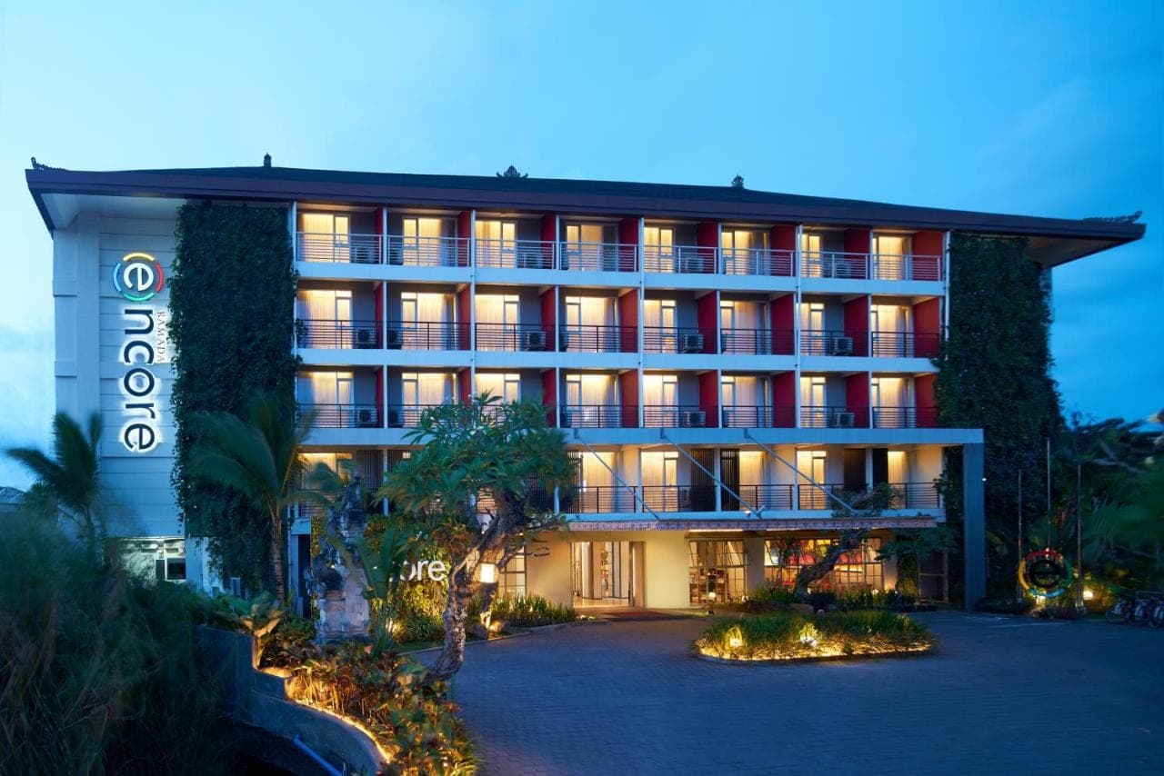 an exterior view of a hotel at night at Ramada Encore by Wyndham Seminyak Bali in Seminyak