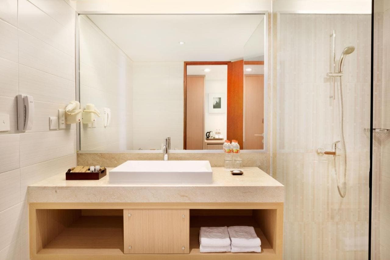 a bathroom with a sink and a shower at Ramada Encore by Wyndham Seminyak Bali in Seminyak