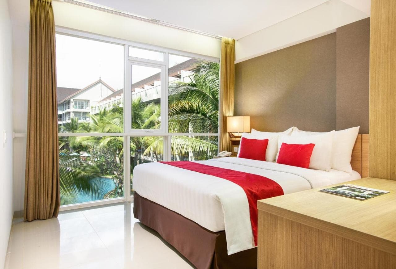 a bedroom with a large bed and a large window at Ramada Encore by Wyndham Seminyak Bali in Seminyak