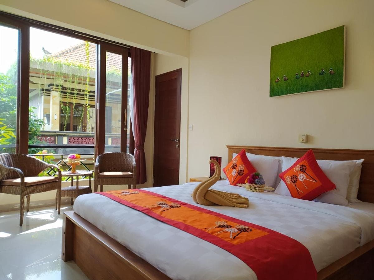 a bedroom with a large bed and a large window at Donald Home Stay in Ubud