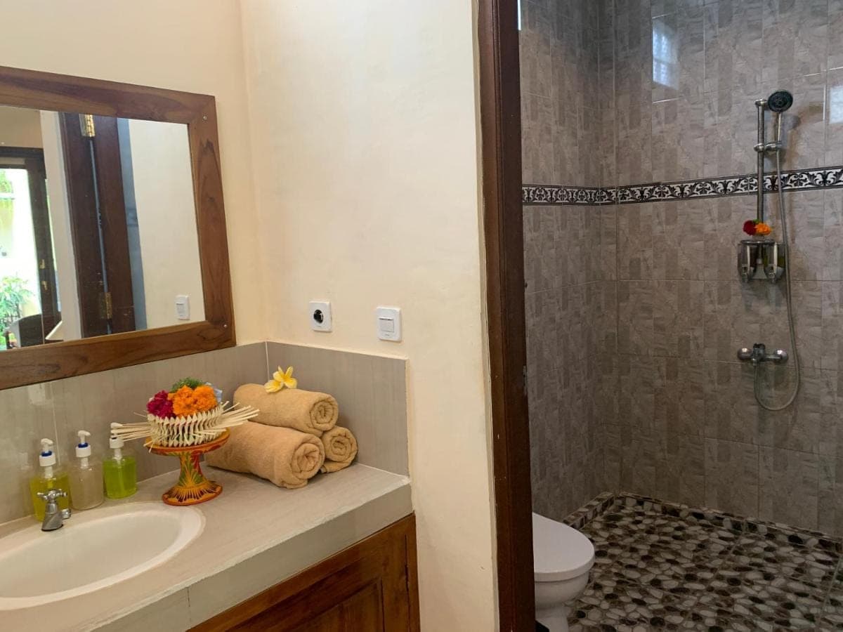 a bathroom with a sink and a shower and a toilet at Donald Home Stay in Ubud