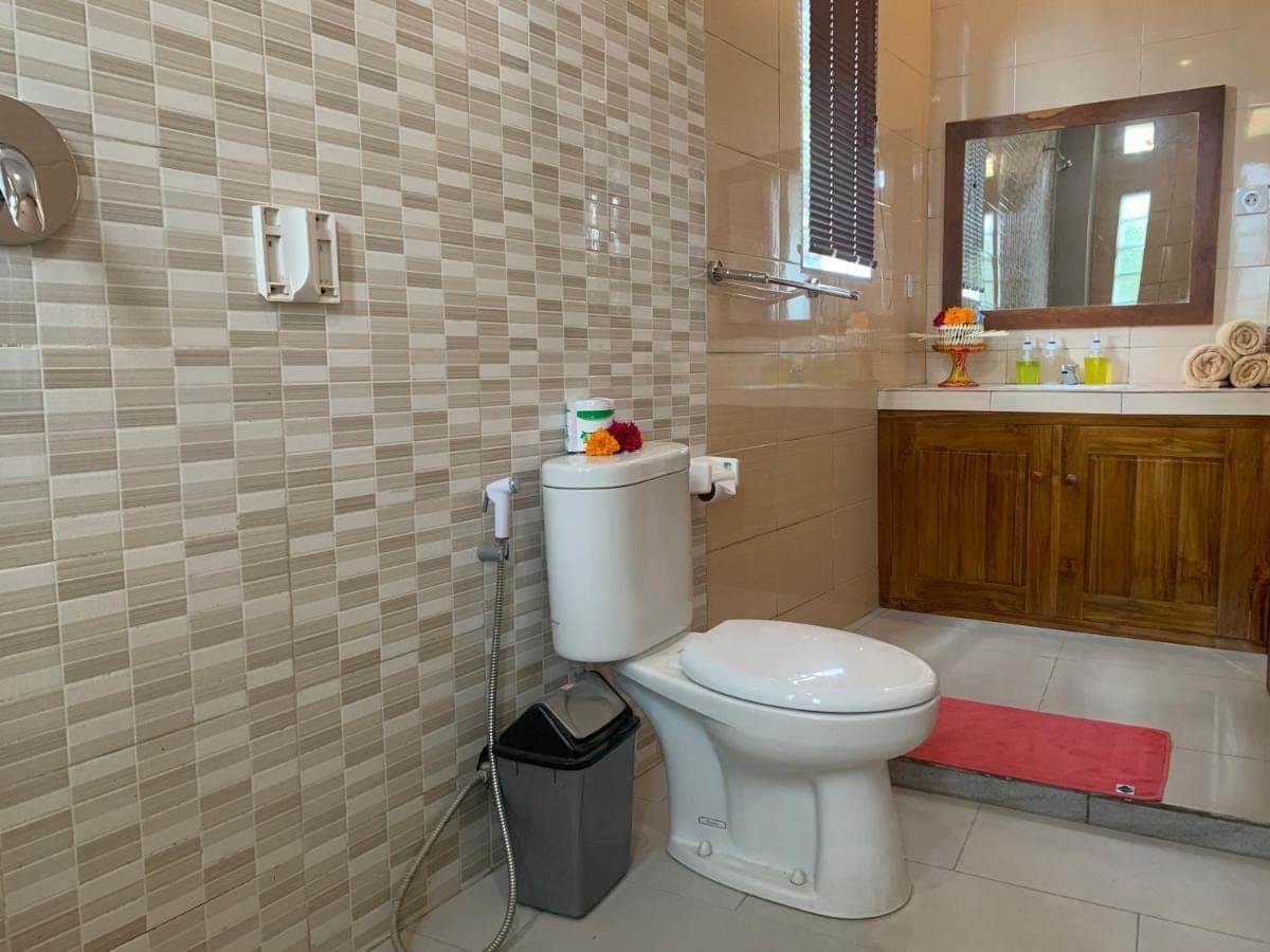 a bathroom with a toilet and a sink at Donald Home Stay in Ubud