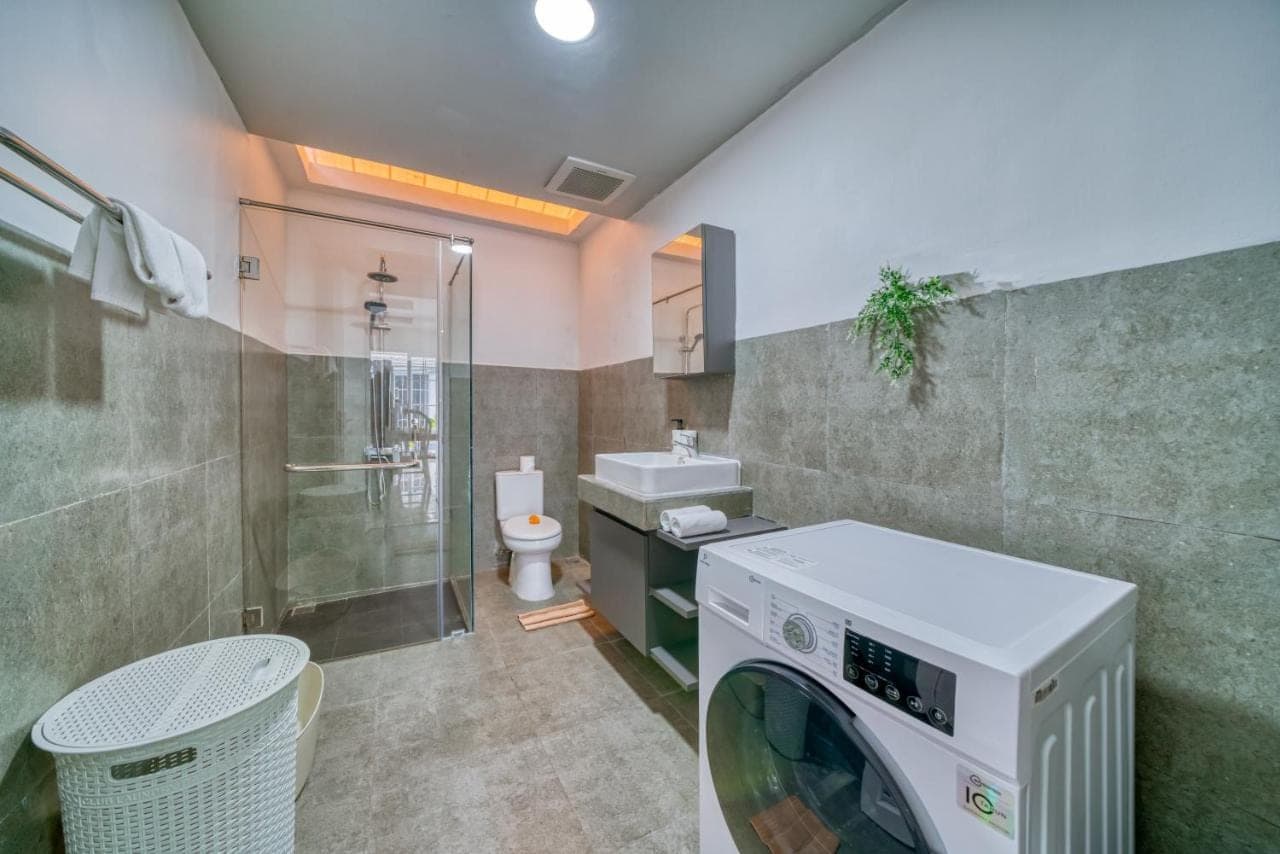 a washing machine in a bathroom with a toilet at 3BD Modern Apartment in Sanur with BBQ & huge shared pool in Sanur
