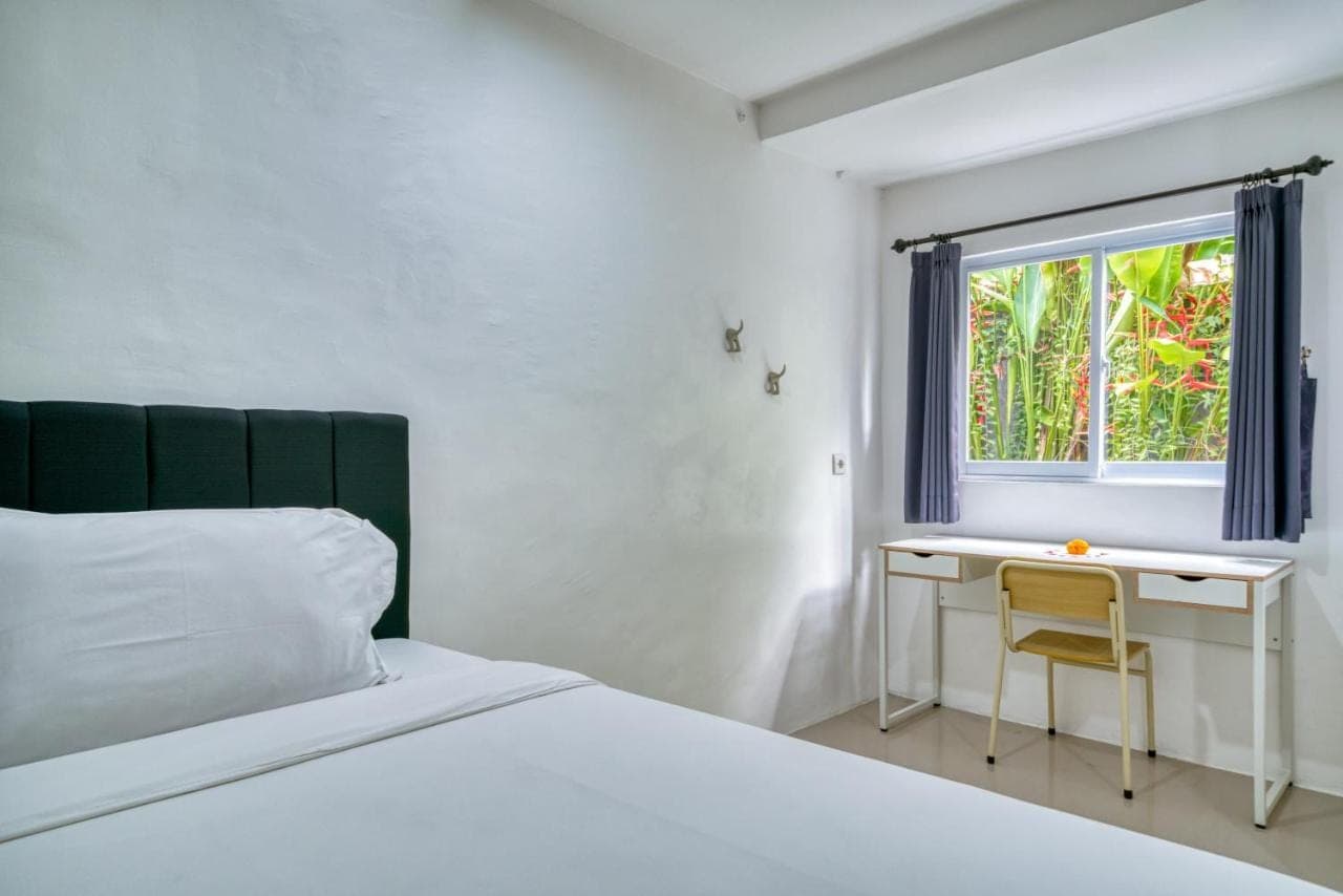 a bedroom with a bed and a desk and a window at 3BD Modern Apartment in Sanur with BBQ & huge shared pool in Sanur