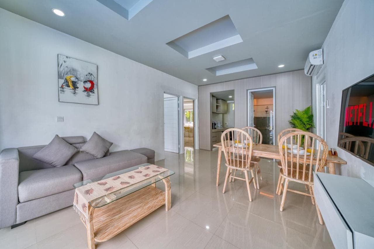 a living room with a couch and a table and chairs at 3BD Modern Apartment in Sanur with BBQ & huge shared pool in Sanur