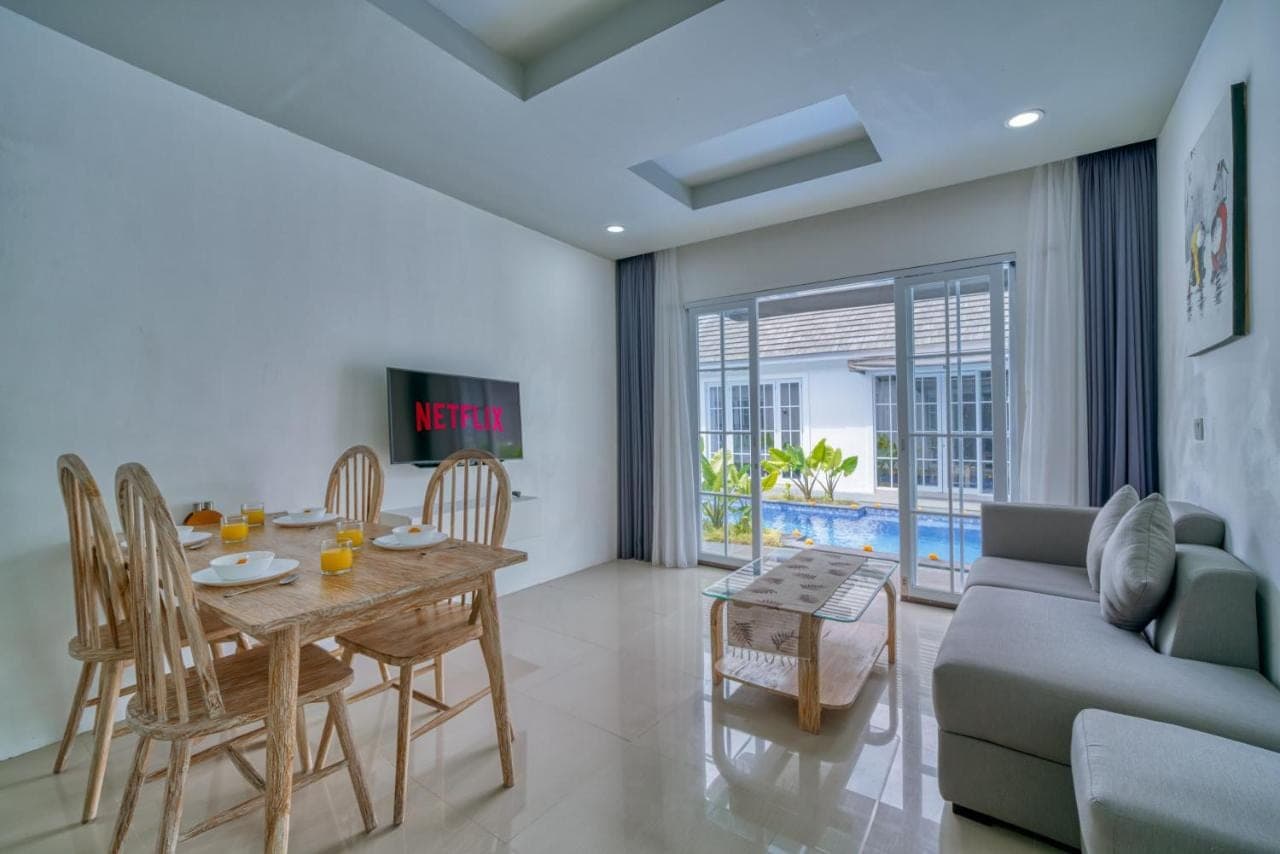 a living room with a table and a couch at 3BD Modern Apartment in Sanur with BBQ & huge shared pool in Sanur