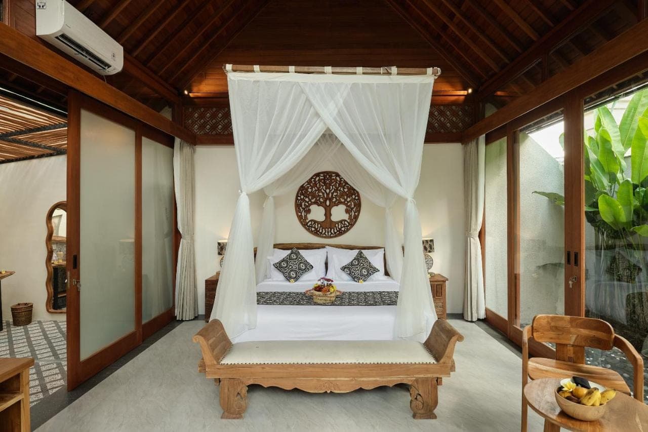 a bedroom with a bed with a canopy at Changi Jungle Ubud Villas in Ubud