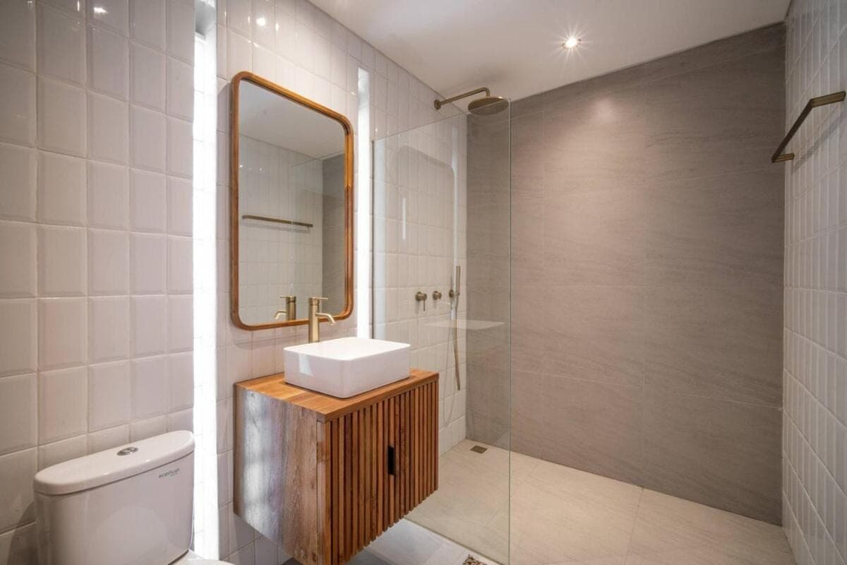a bathroom with a sink and a toilet and a mirror at Pererenan Gate Brand New 1BR Retreat In Canggu in Canggu