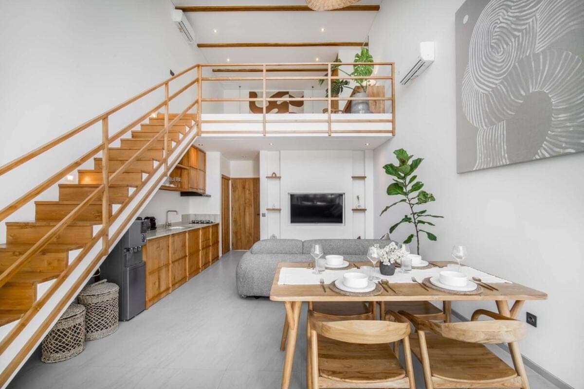 a kitchen and living room with a table and a staircase at Pererenan Gate Brand New 1BR Retreat In Canggu in Canggu