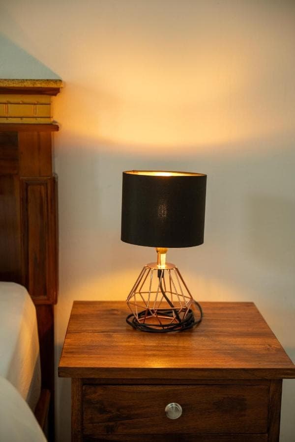 a lamp on a wooden table in a bedroom at Dream Breeze Village Uluwatu in Uluwatu
