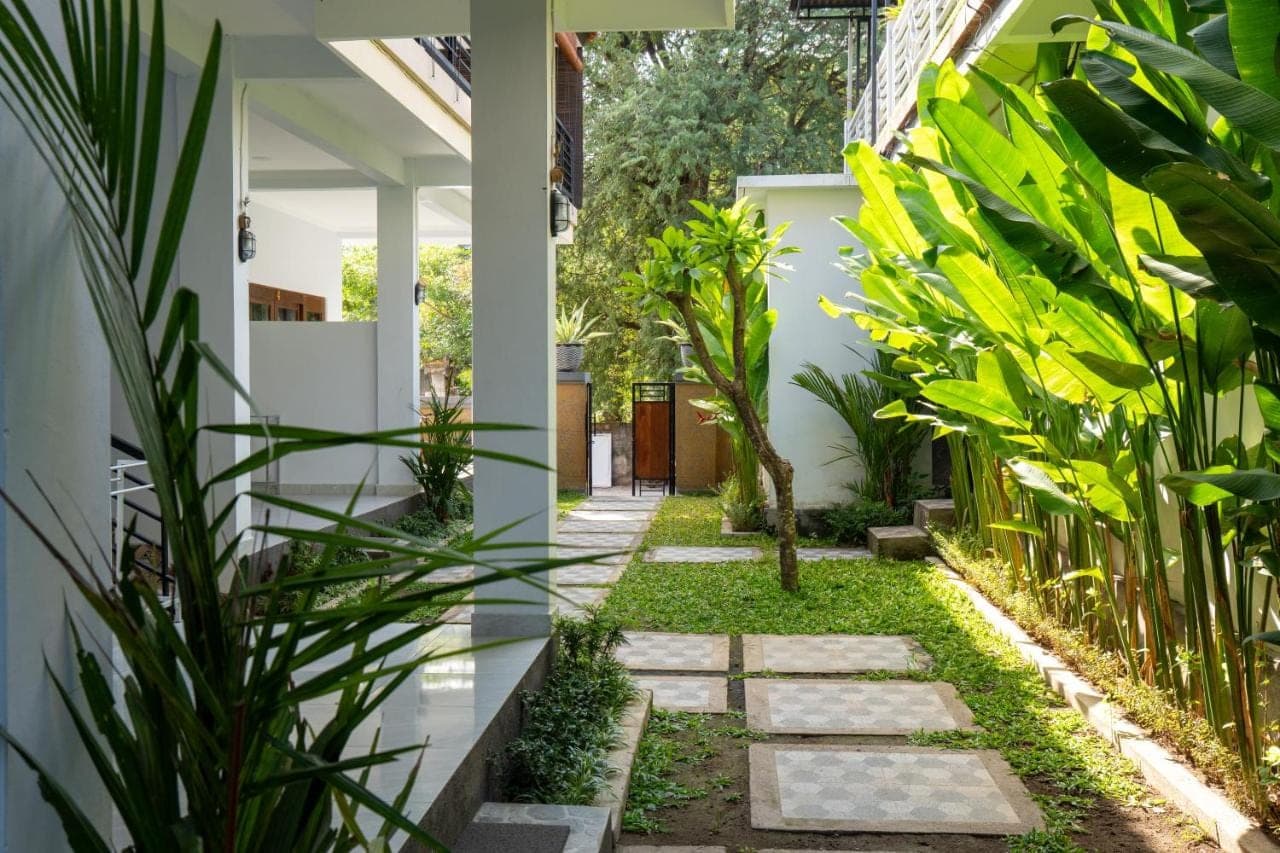 a garden in the middle of a house with plants at Holiday Guest House in Amed