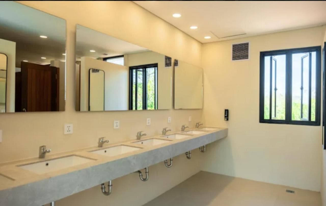 a row of sinks in a bathroom with mirrors at Lay Day Party and Surf Hostel Uluwatu in Uluwatu