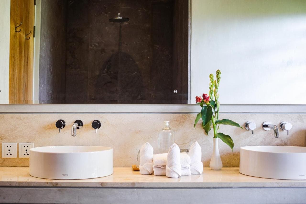 a bathroom with two sinks and a mirror at MASMARA Resort Canggu in Canggu