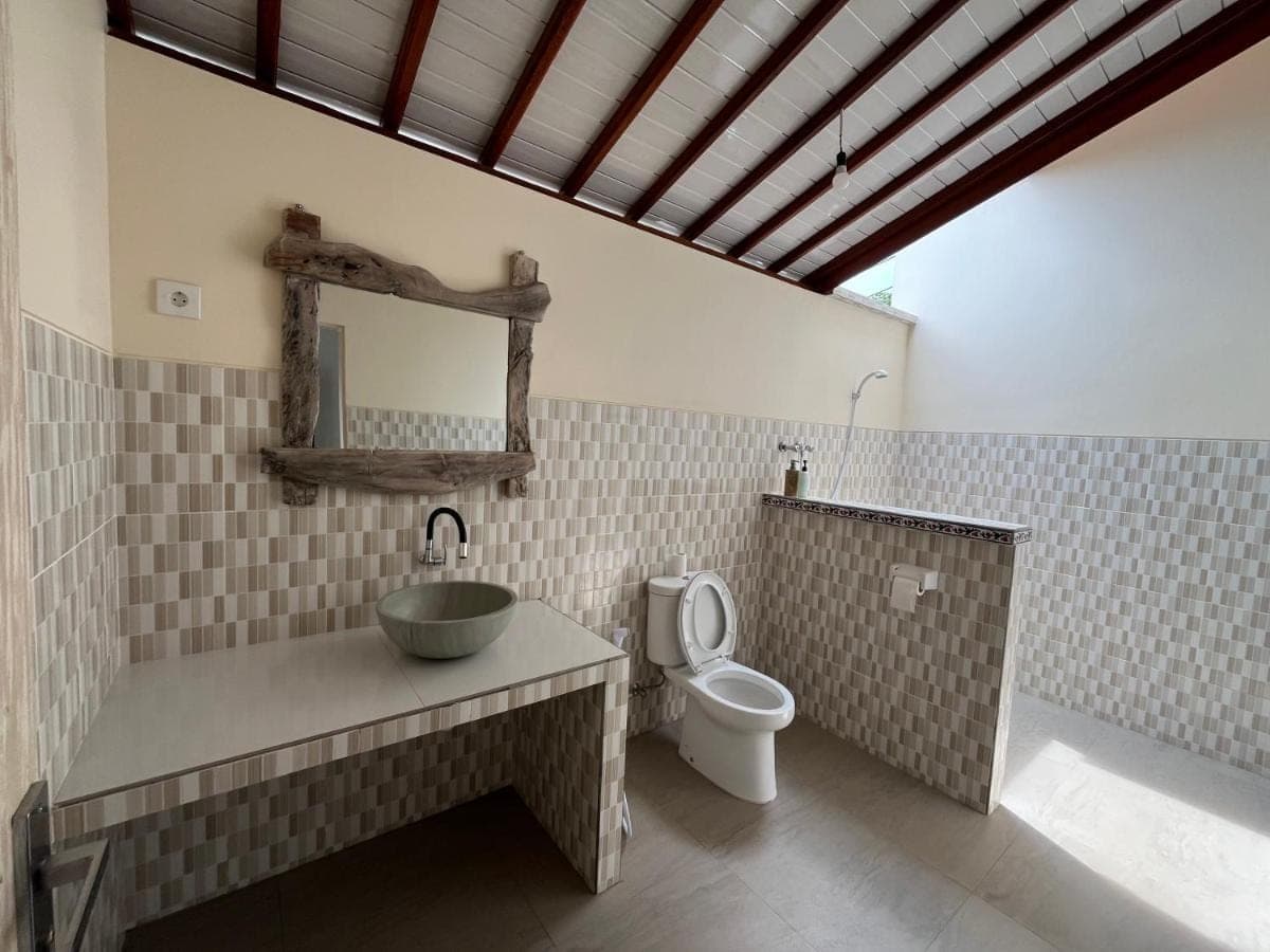 a bathroom with a sink and a toilet at Ganesha Amed in Amed
