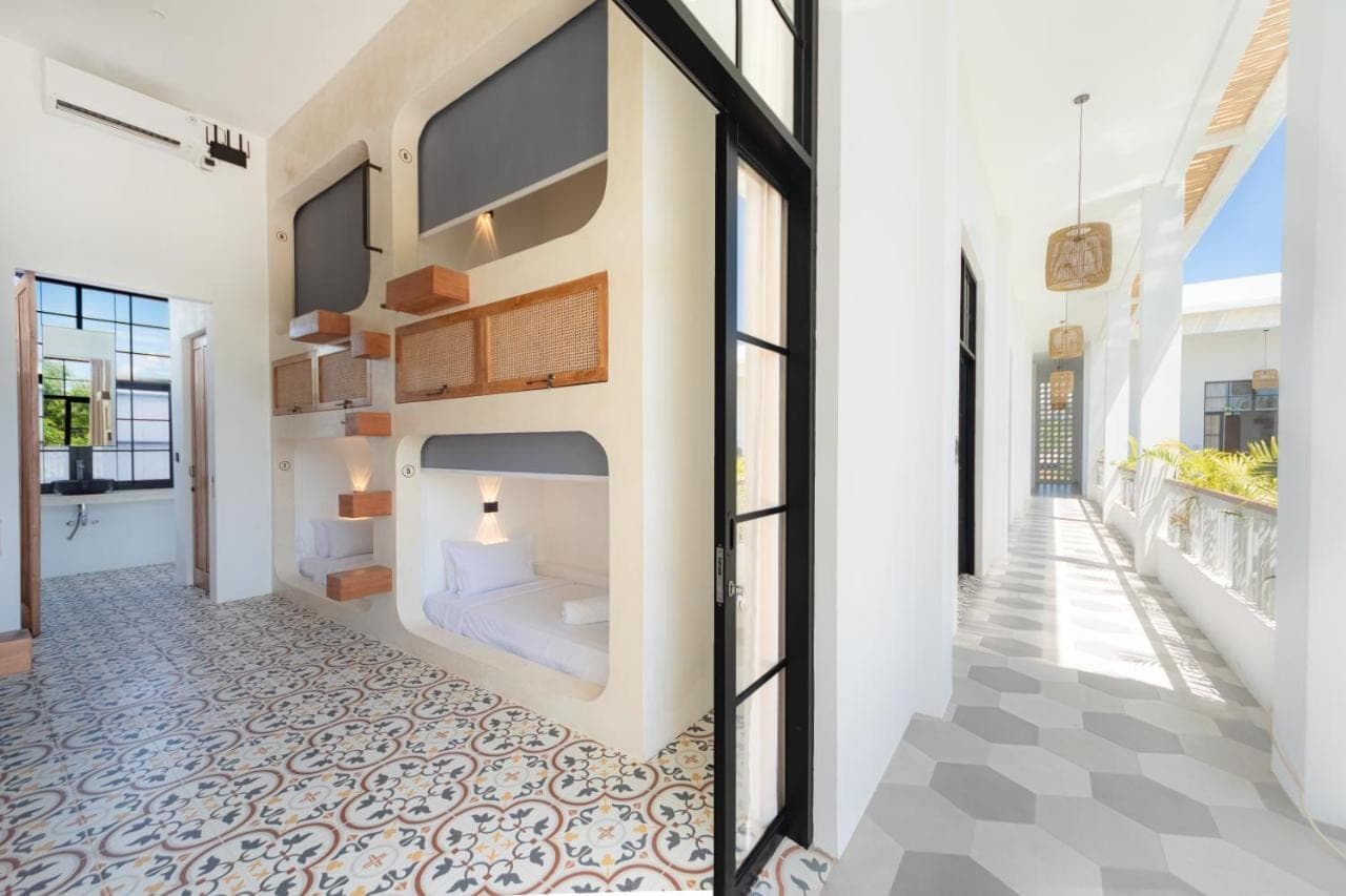 a bedroom with a bed in a wall at The Lazy Lama Hostel Uluwatu in Uluwatu