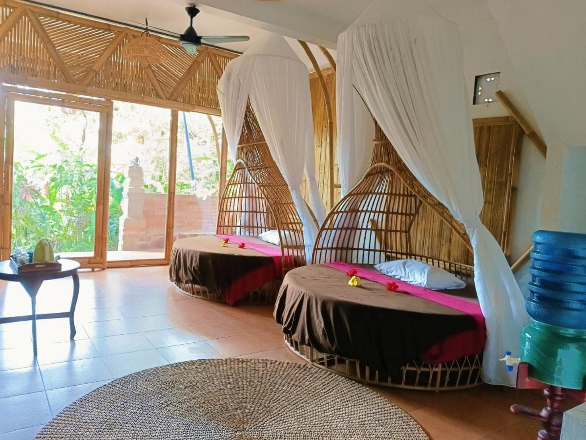 a room with two beds with mosquito nets in it at Great Mountain Views Nature Resort in Sidemen