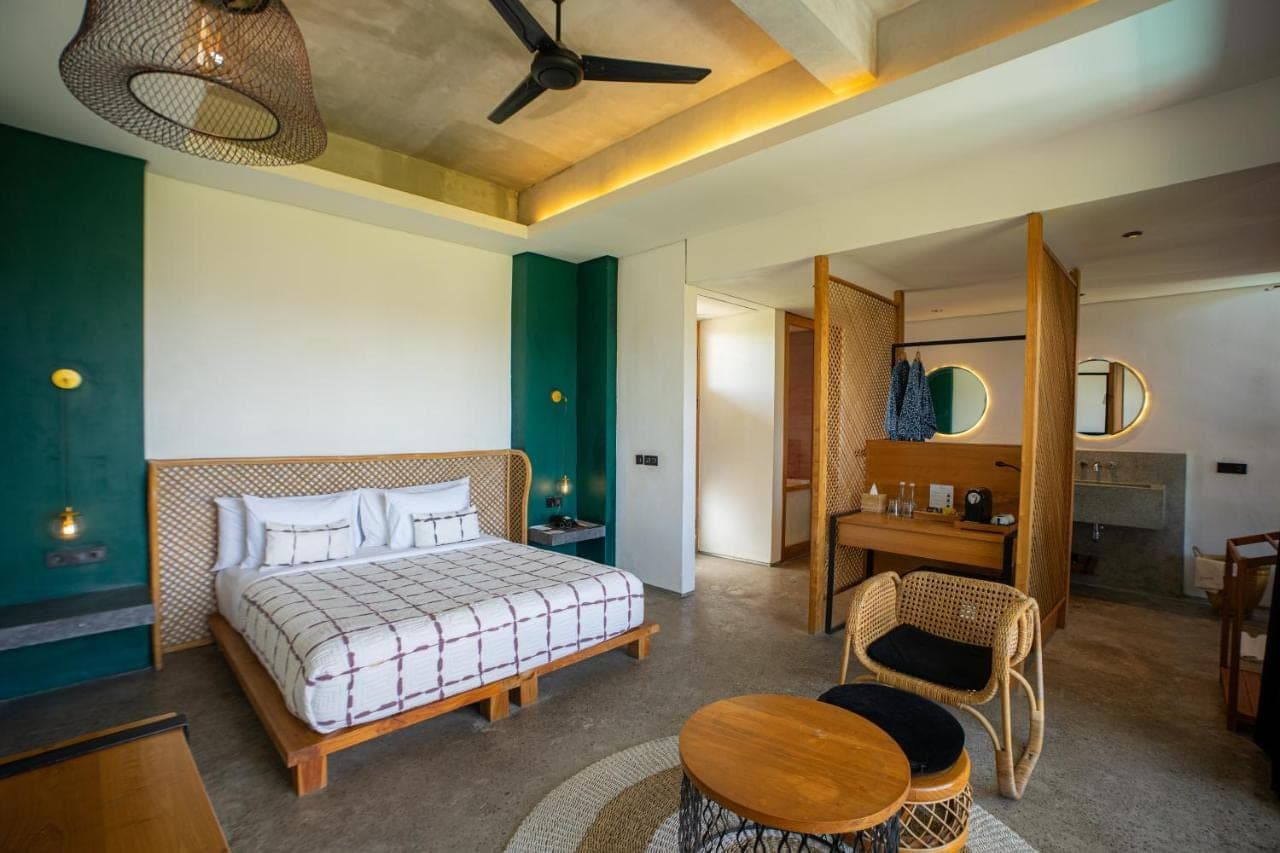 a bedroom with a bed and a table in a room at Shore Amora Canggu in Canggu