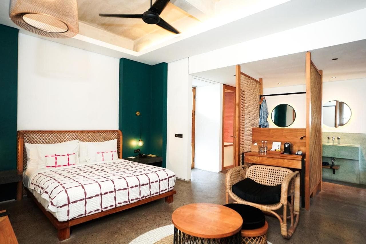 a bedroom with a bed and a table and a chair at Shore Amora Canggu in Canggu