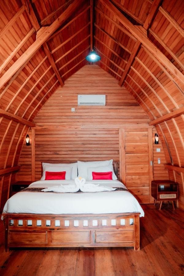 a bedroom with a bed in a wooden room at Nusa Dua Huts Pondok Gajah Para by EPS in Nusa Dua