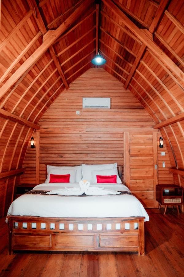 a bedroom with a bed in a wooden room at Nusa Dua Huts Pondok Gajah Para by EPS in Nusa Dua