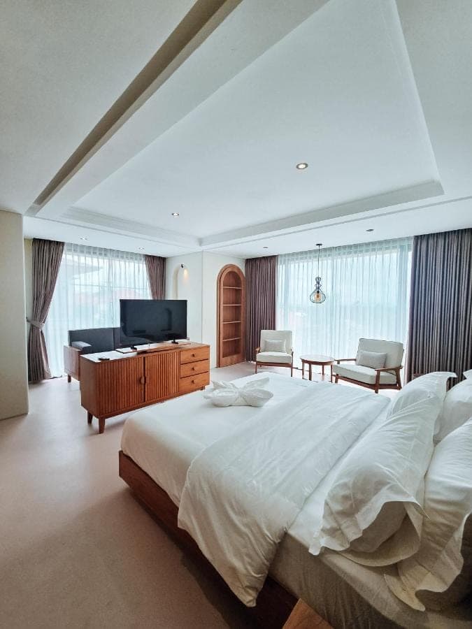 a large bedroom with a large bed and a television at Mattea Guest House Nusa Dua Bali in Nusa Dua