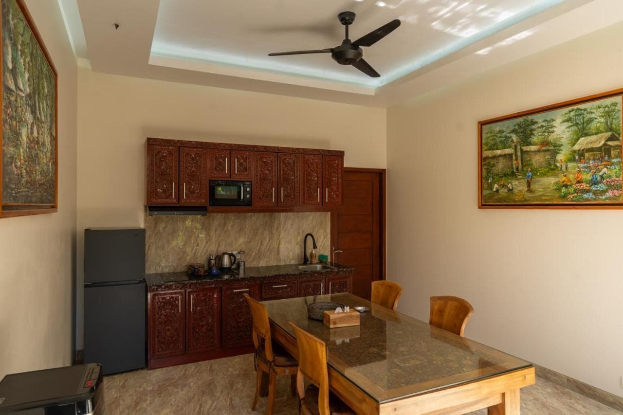 a kitchen with a table and a ceiling fan at Amed Paradise Beach Club in Amed