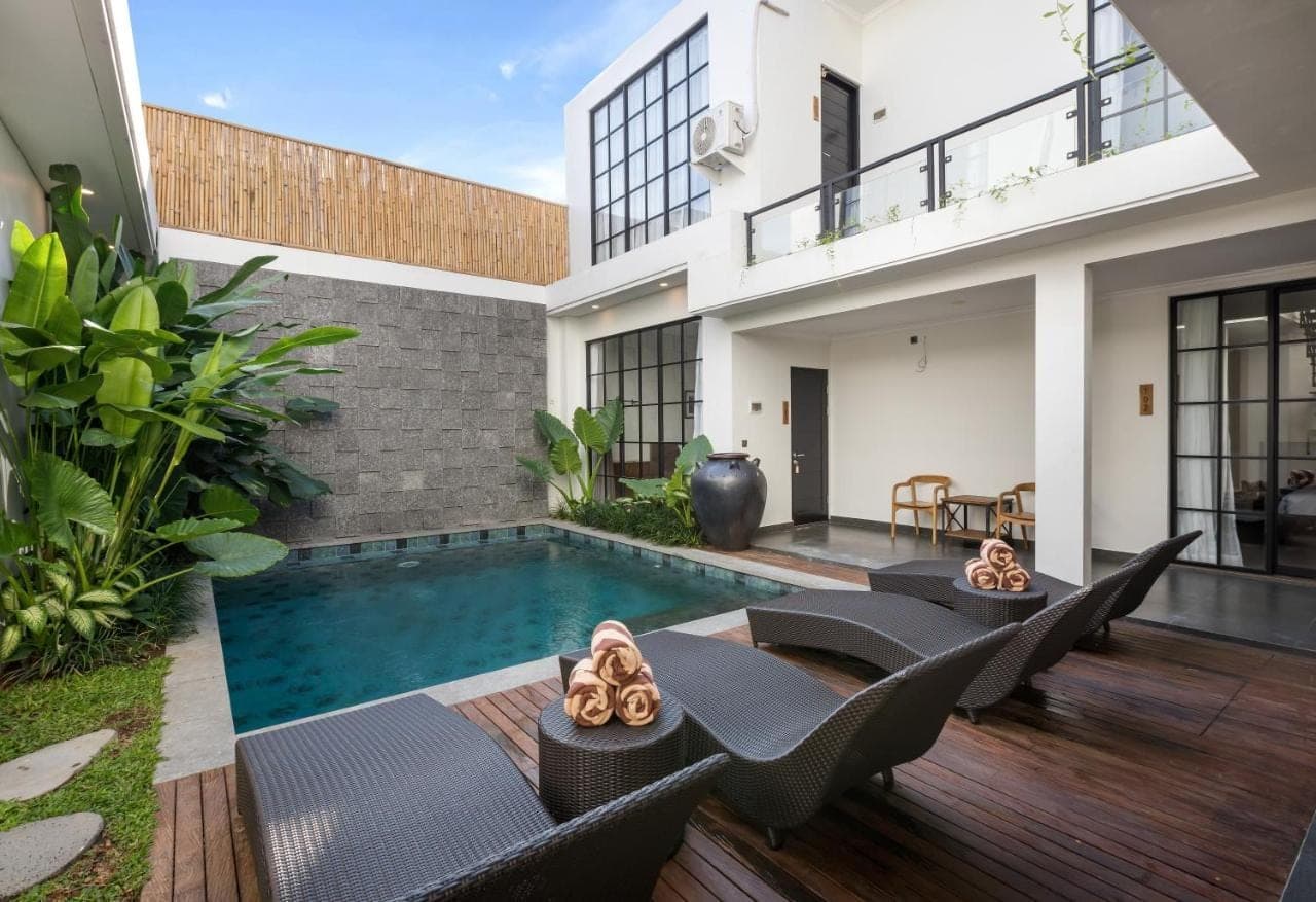 a villa with a swimming pool and a house at Beach8 Canggu by Kerta Living in Canggu