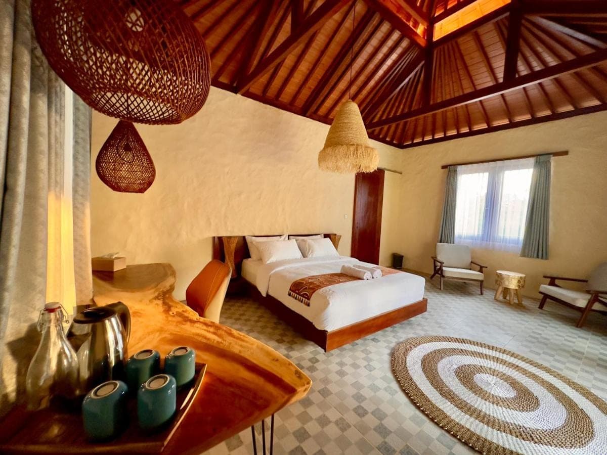 a bedroom with a bed and a table in a room at Sanur ocean view villas in Sanur