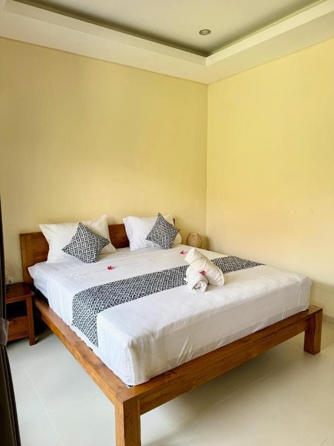 a bedroom with a bed with a teddy bear on it at Dega Gardens in Canggu