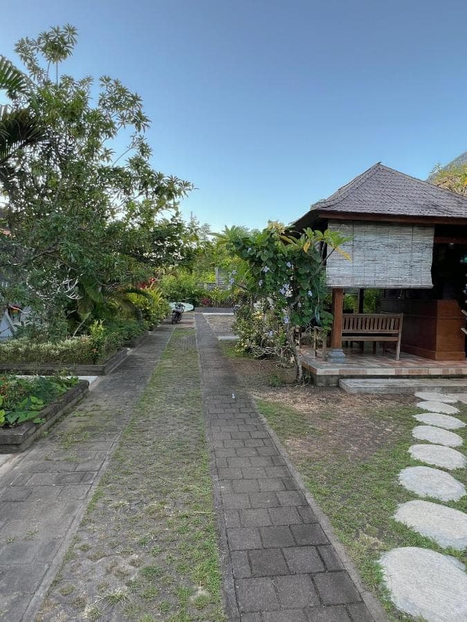a path leading to a building with a bench at D'pandawa guest house in Nusa Dua