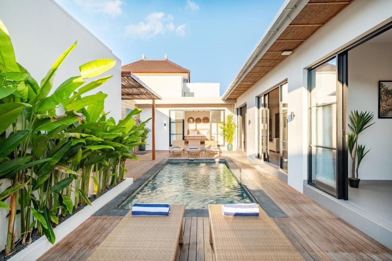 an infinity pool in the middle of a house with plants at CHAO Villas Rooms Recovery Spa in Uluwatu