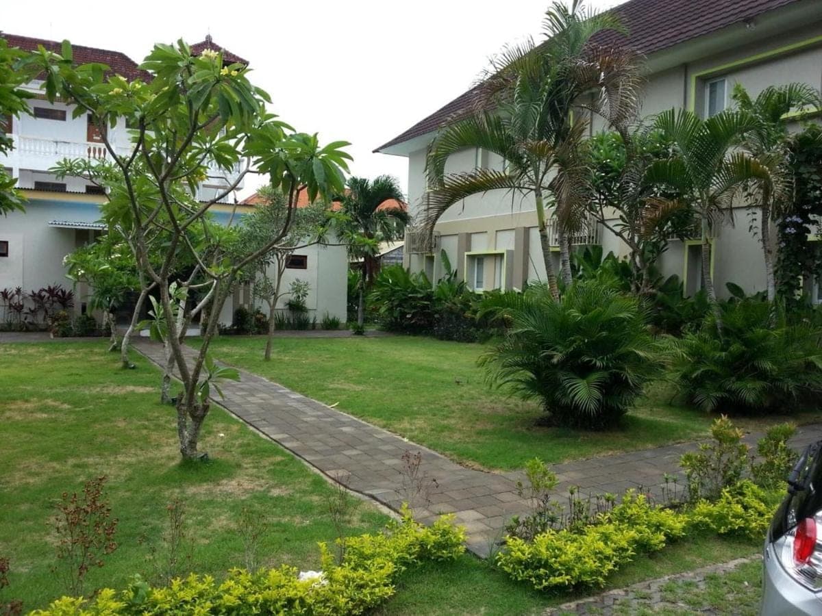 a garden in front of a house at Kemuning Kuta Hotel in Kuta