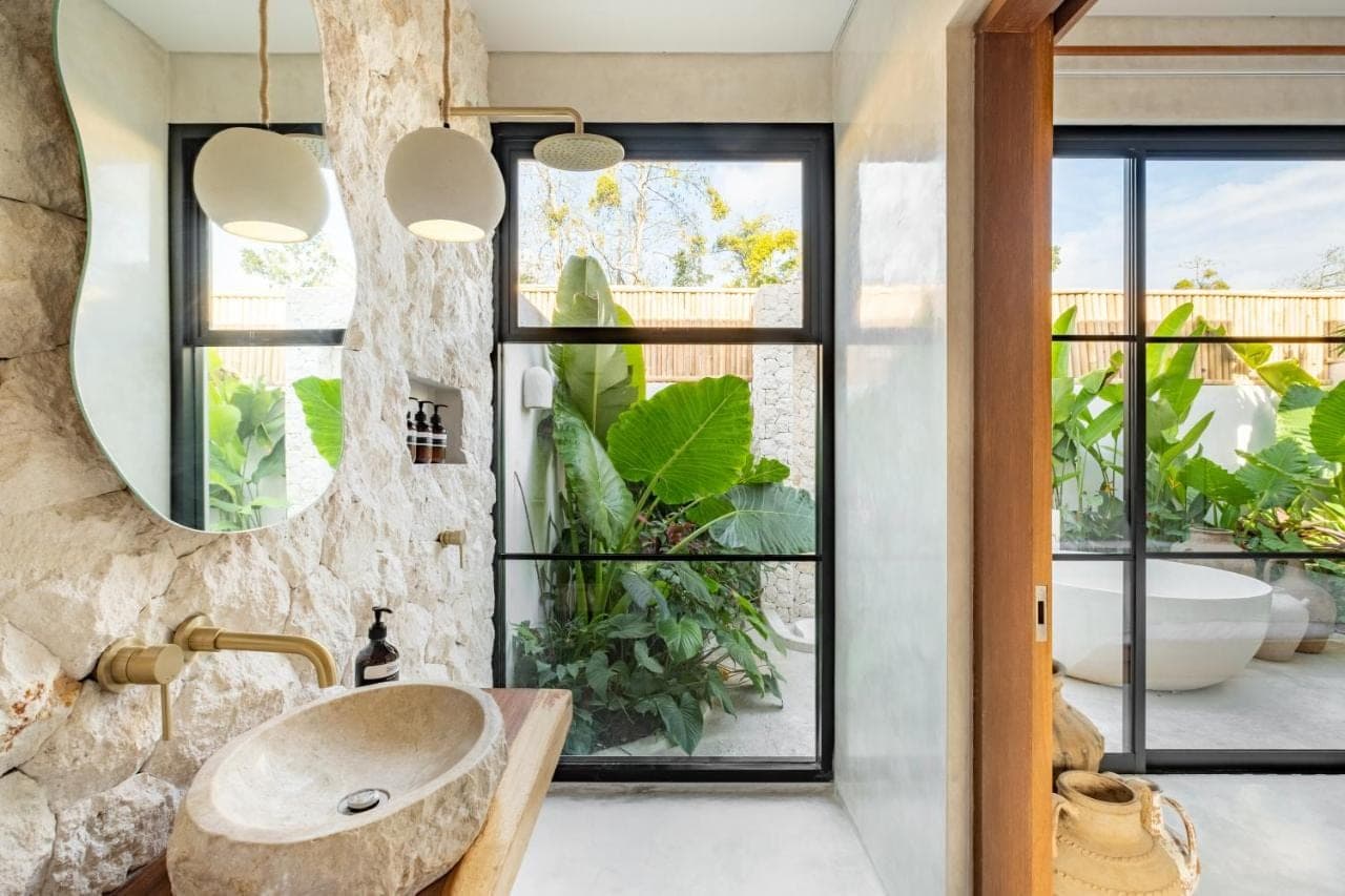 a bathroom with a sink and a large window at Alma Bingin Boutique Hotel in Uluwatu