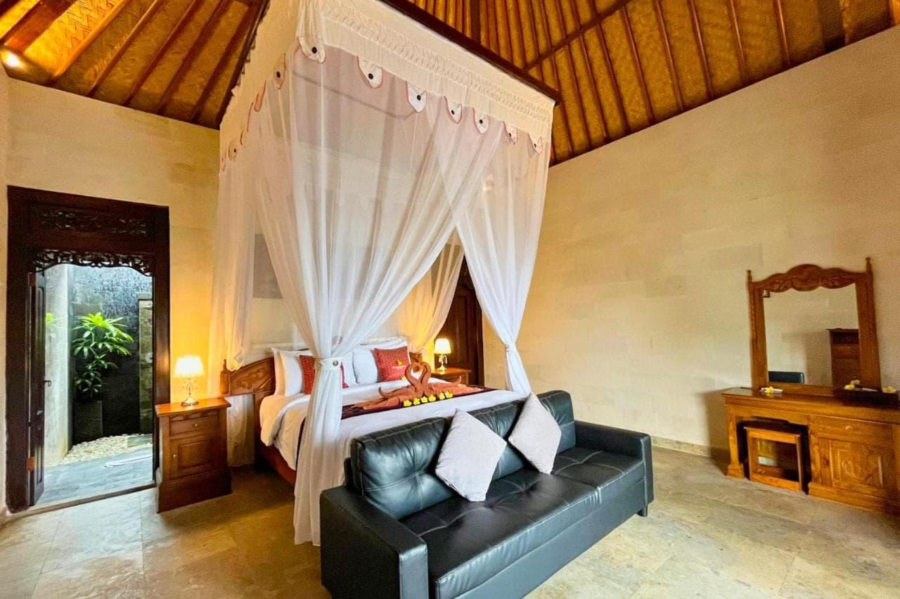a bedroom with a bed and a couch in a room at Villa Pastiny Santy Sidemen in Sidemen