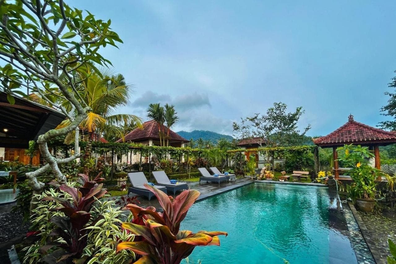 a pool at a resort with chairs and trees at Villa Pastiny Santy Sidemen in Sidemen