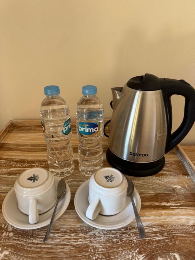 a tea kettle and two bottles of water on a table at Comeon Amed in Amed