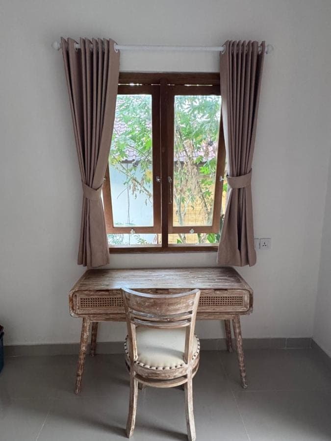 a table and a chair in front of a window at Comeon Amed in Amed