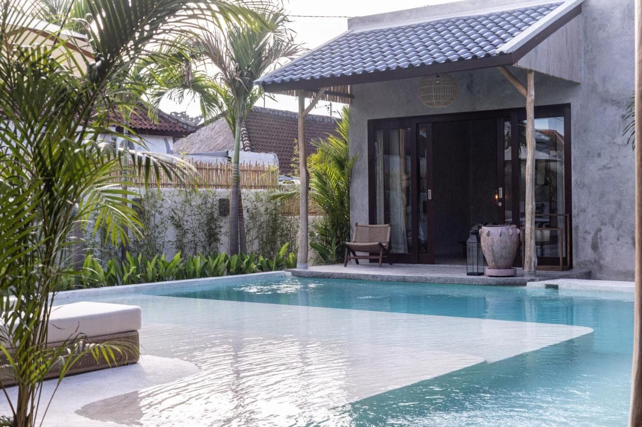 a swimming pool in front of a house at Kano Twin in Canggu