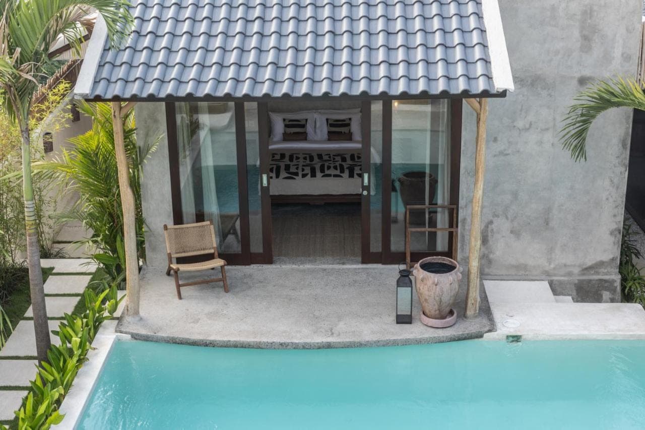 a house with a swimming pool in front of a house at Kano Twin in Canggu