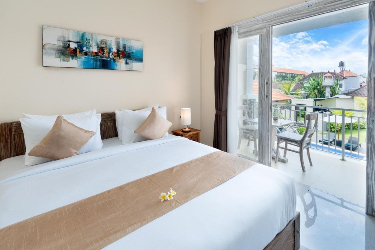 a bedroom with a bed and a large window at The Kifaraju Nusa Dua Bali in Nusa Dua
