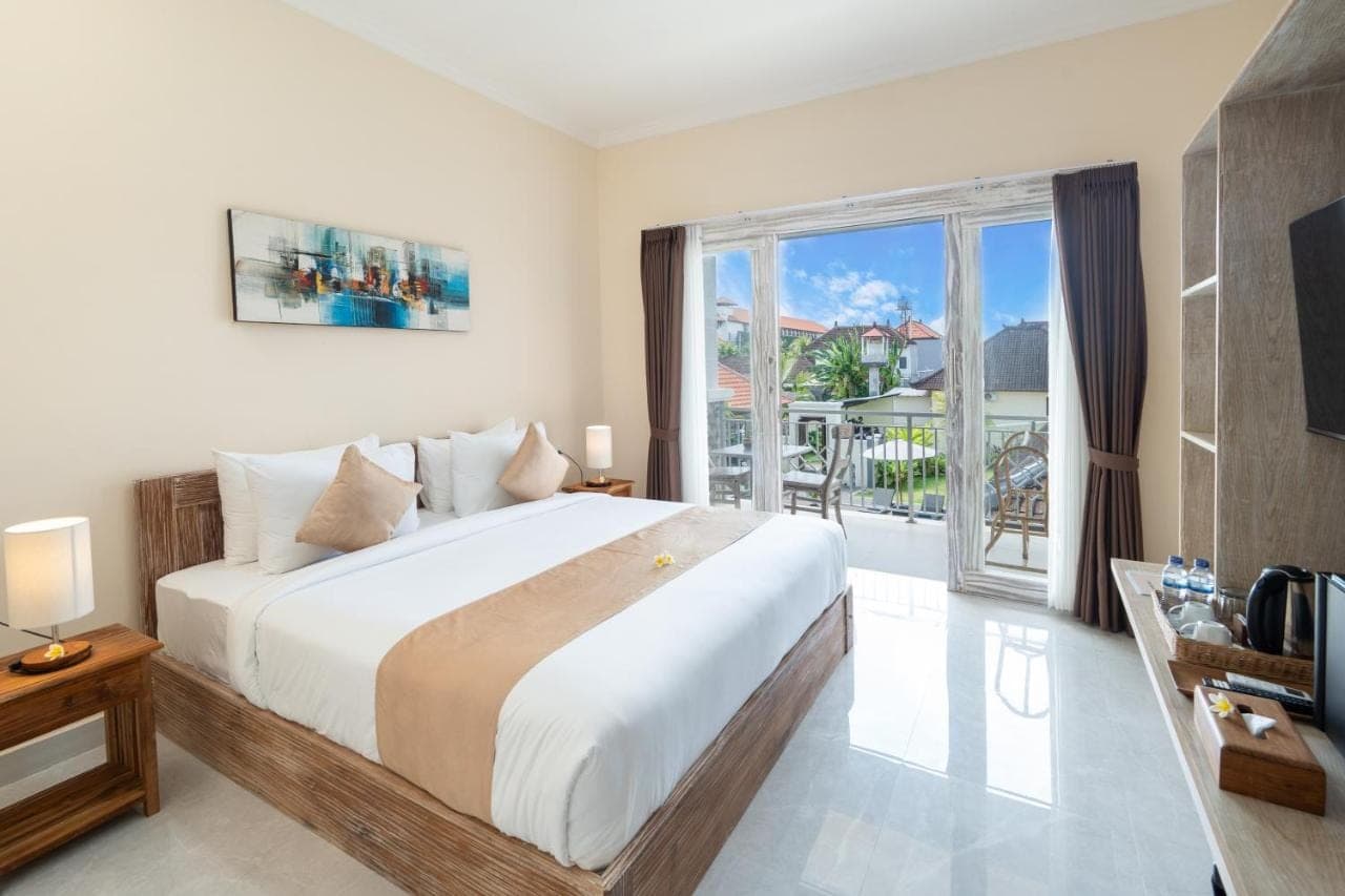 a bedroom with a large bed and a large window at The Kifaraju Nusa Dua Bali in Nusa Dua